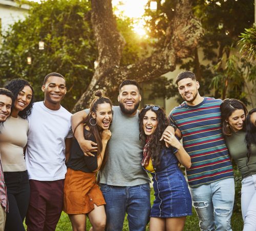 Portrait of cheerful friends. Young multi-ethnic males and females are wearing casuals. They are enjoying in party at back yard.